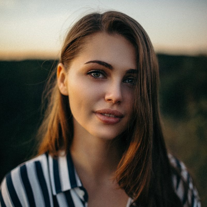 smiling woman wearing white and black pinstriped collared top